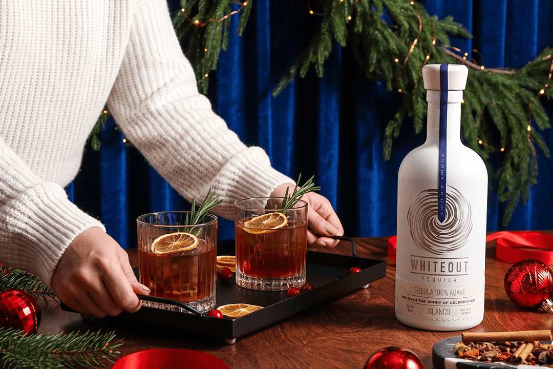 Whiteout Tequila Blanco served with festive holiday tequila cocktails, rosemary, dried citrus, and Christmas decor for seasonal celebrations.
