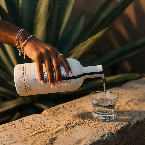 Woman pouring Whiteout tequila into a shot