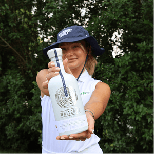 Person holding a bottle of Whiteout in an outdoor setting
