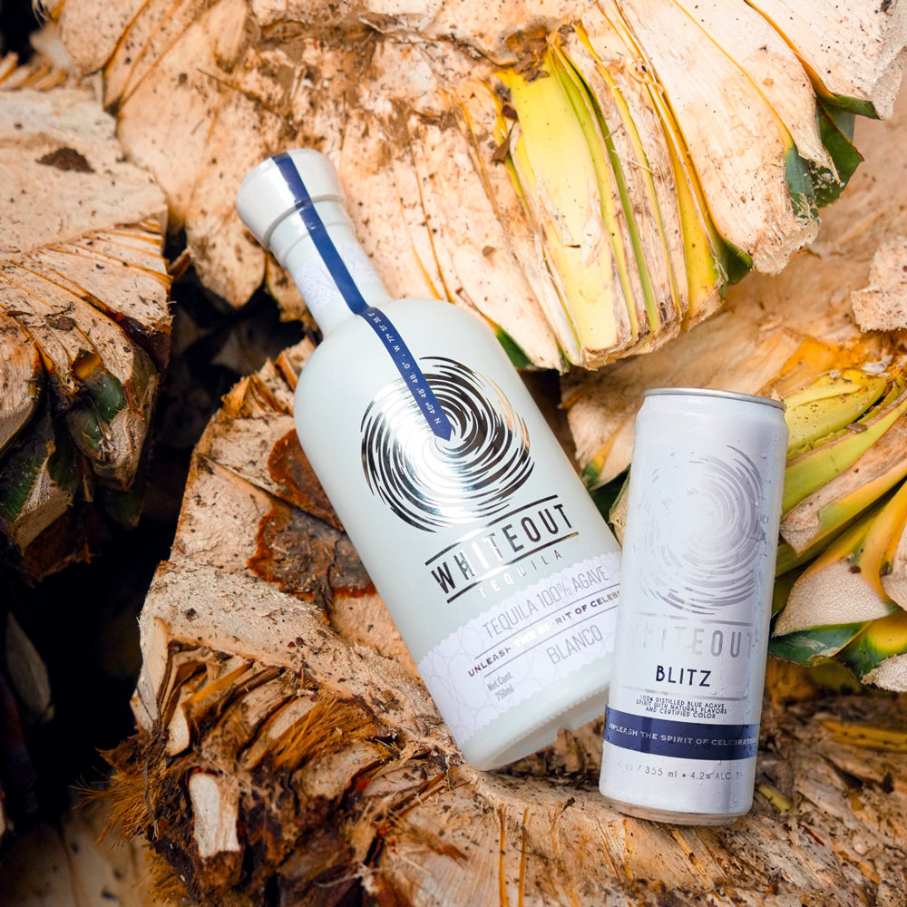 Whiteout Blanco bottle and Blitz can over a pile of agave