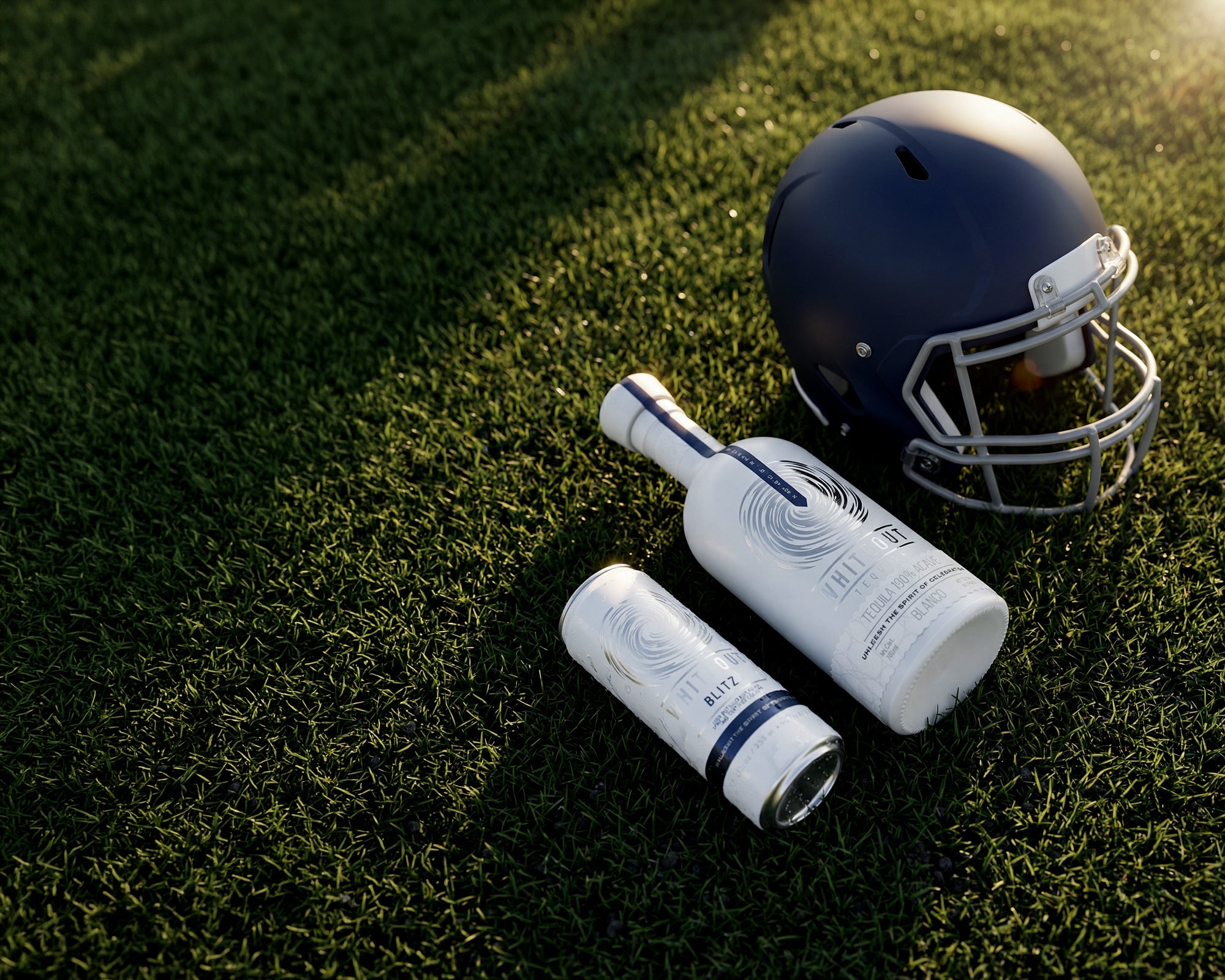 Whiteout tequila products layed on a football field next to a helmet